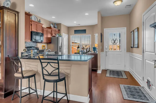 a kitchen with stainless steel appliances granite countertop a refrigerator and a stove top oven