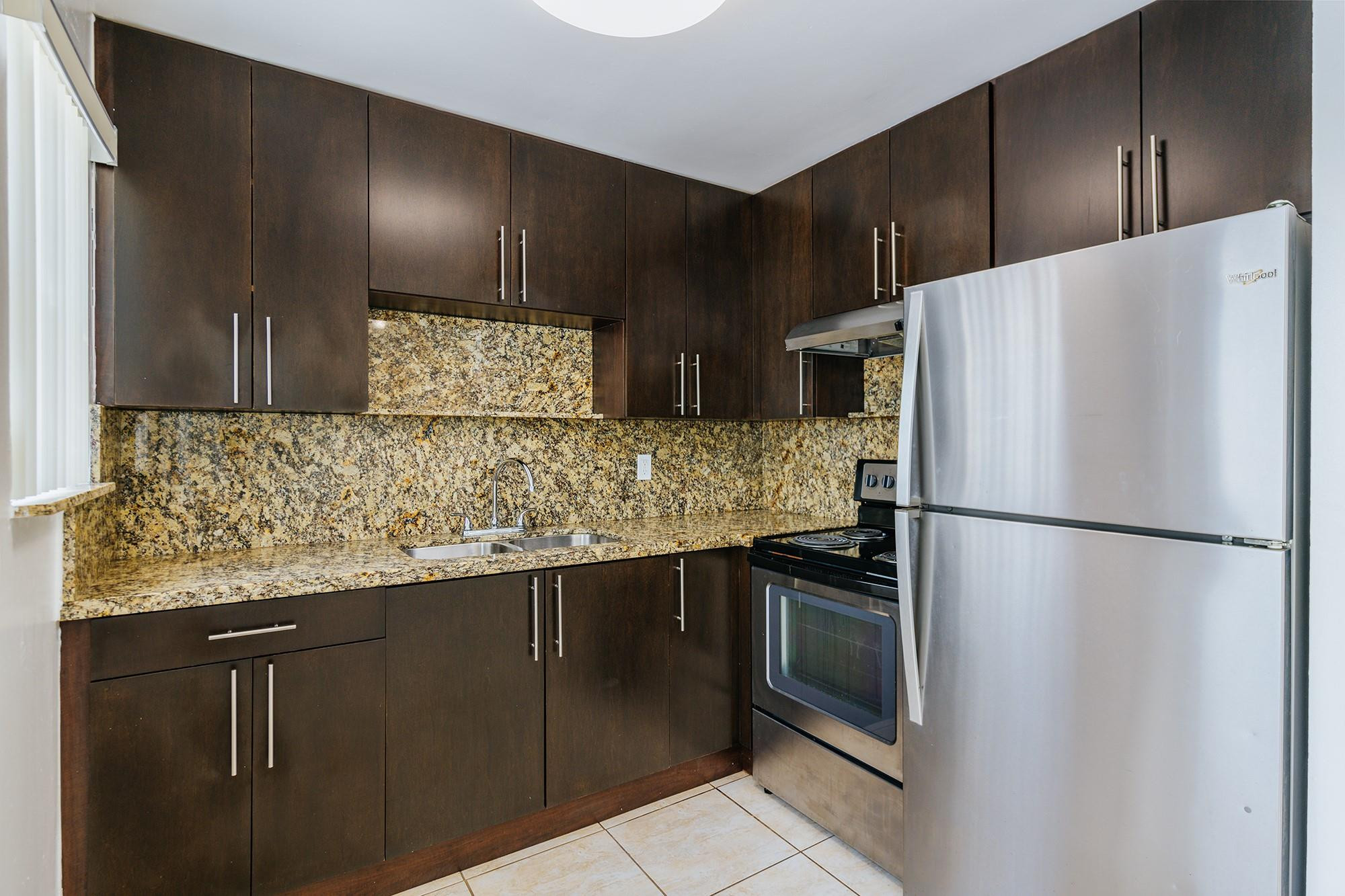 3500 Jackson Street, Unit 105 Hollywood, FL 33021 - Photo 10 of 14 a white refrigerator freezer sitting inside of a kitchen