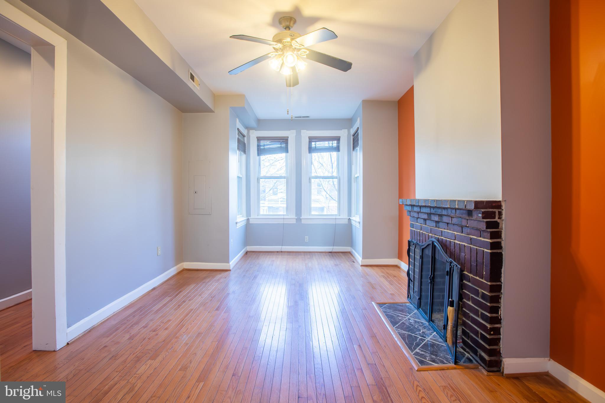 1117 I Street Northeast Washington, DC 20002 - Photo 5 of 23 wooden floor in an empty room with a fireplace and a window