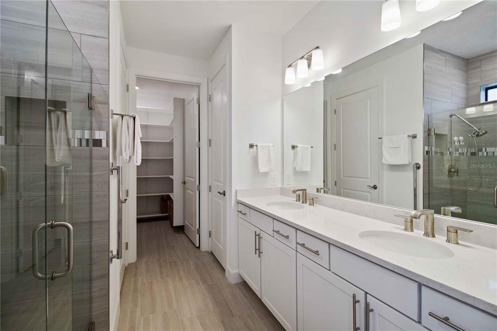6713 Alstead Circle Lakewood Ranch, FL 34202 - Photo 18 of 35 a spacious bathroom with a shower sink and mirror