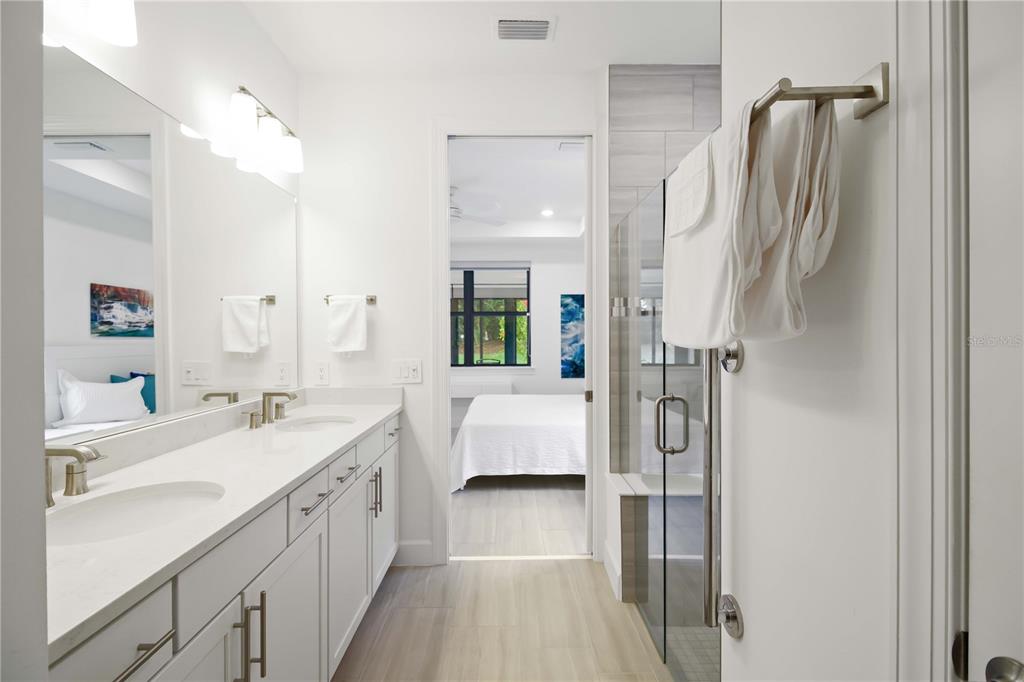 6713 Alstead Circle Lakewood Ranch, FL 34202 - Photo 19 of 35 a en suite bathroom with a double vanity sink a large mirror and shower