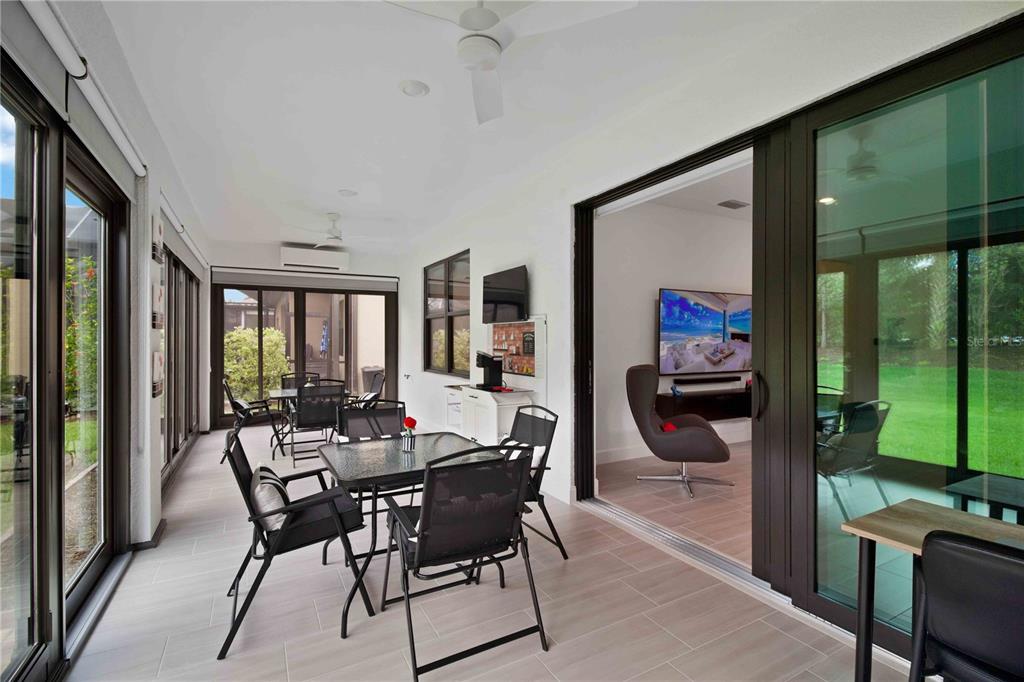 6713 Alstead Circle Lakewood Ranch, FL 34202 - Photo 24 of 35 a dining room with furniture and a floor to ceiling window