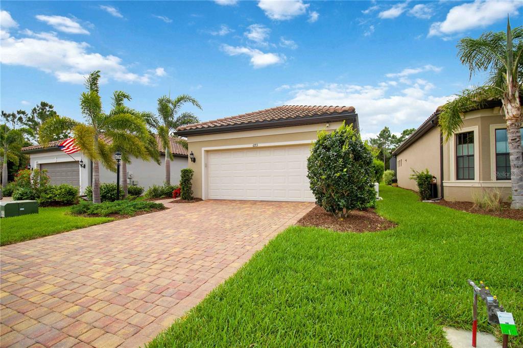 6713 Alstead Circle Lakewood Ranch, FL 34202 - Photo 33 of 35 a front view of a house with a yard and garage