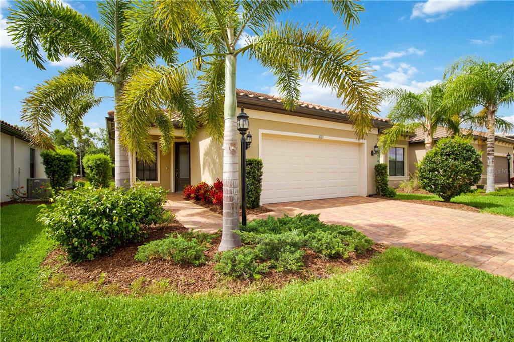 6713 Alstead Circle Lakewood Ranch, FL 34202 - Photo 34 of 35 a front view of a house with a yard and palm trees