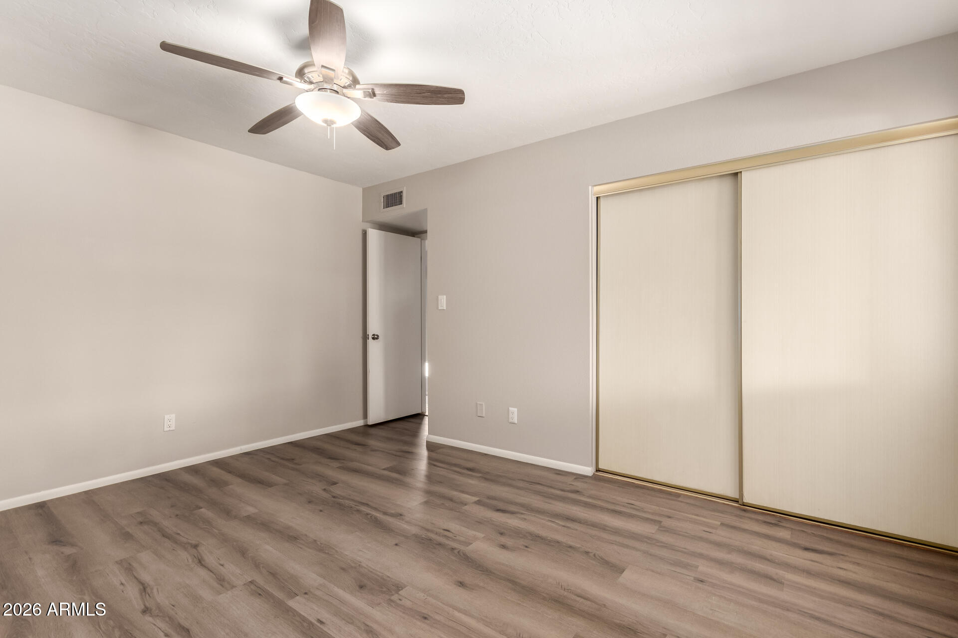 1833 West Citrus Way Phoenix, AZ 85015 - Photo 21 of 36 an empty room with wooden floor fan and windows