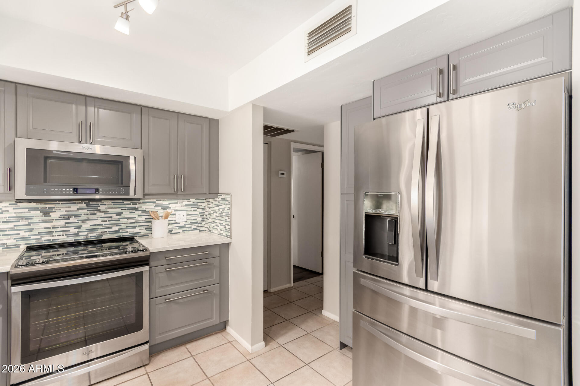 1833 West Citrus Way Phoenix, AZ 85015 - Photo 25 of 36 a kitchen with granite countertop a refrigerator and a stove top oven