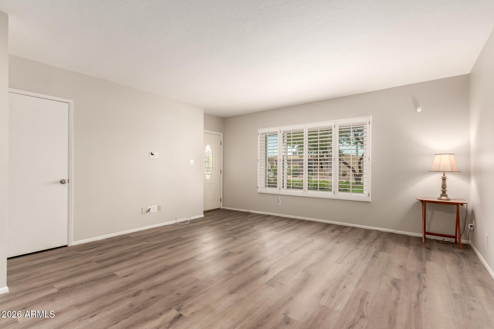 1833 West Citrus Way Phoenix, AZ 85015 - Photo 4 of 36 an empty room with wooden floor and windows
