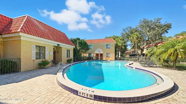 an aerial view of residential houses with outdoor space and lake view