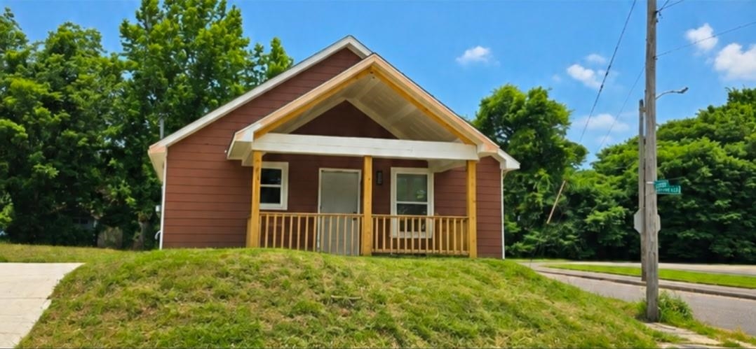 589 Gilleas Road Memphis, TN 38109 - Photo 1 of 9 Gable roofline, covered front porch with wooden railings, wood siding exterior, and a concrete driveway