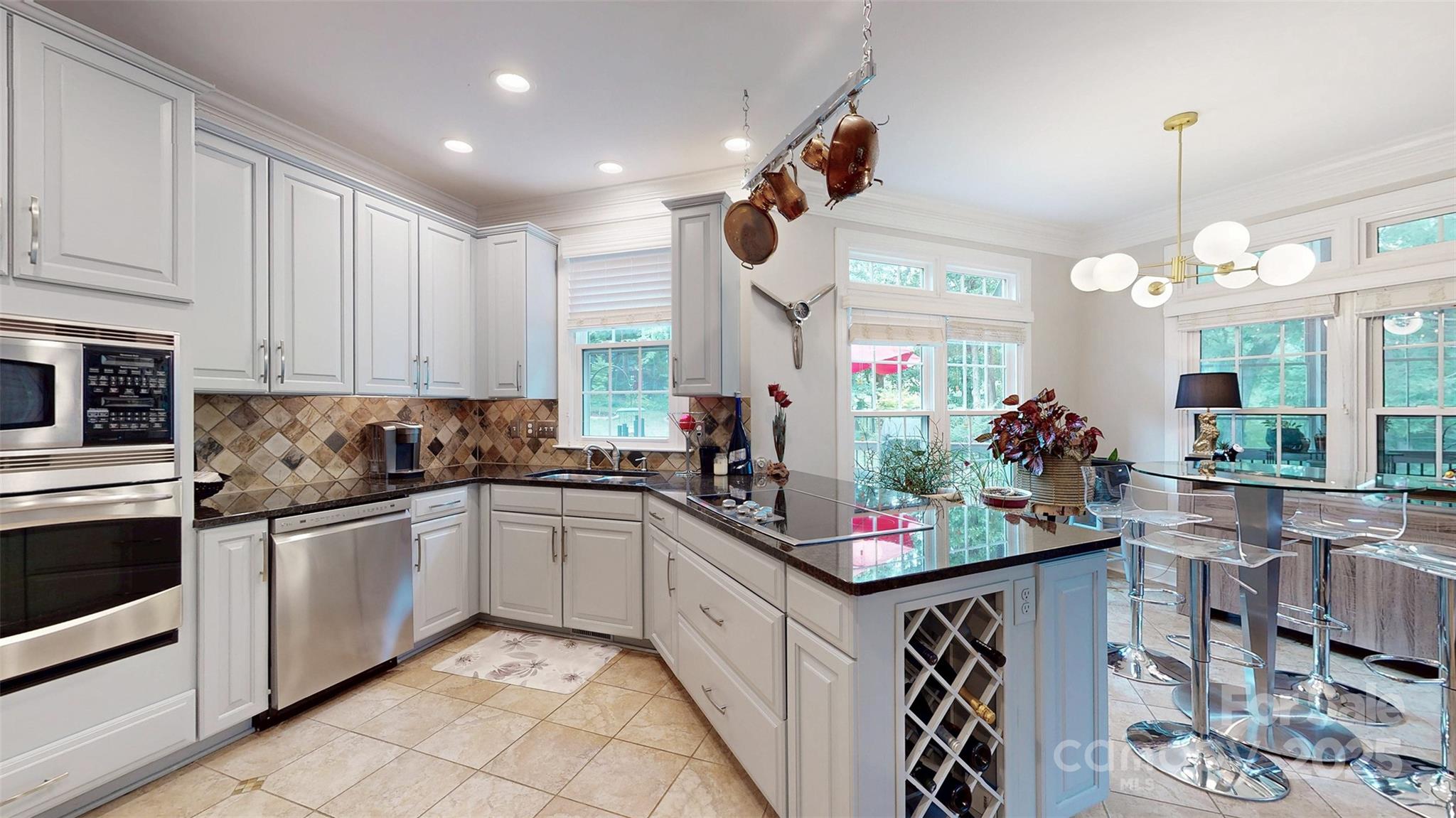 9014 Cardinal Ridge Court Charlotte, NC 28270 - Photo 23 of 45 a kitchen with kitchen island granite countertop a sink cabinets and stainless steel appliances