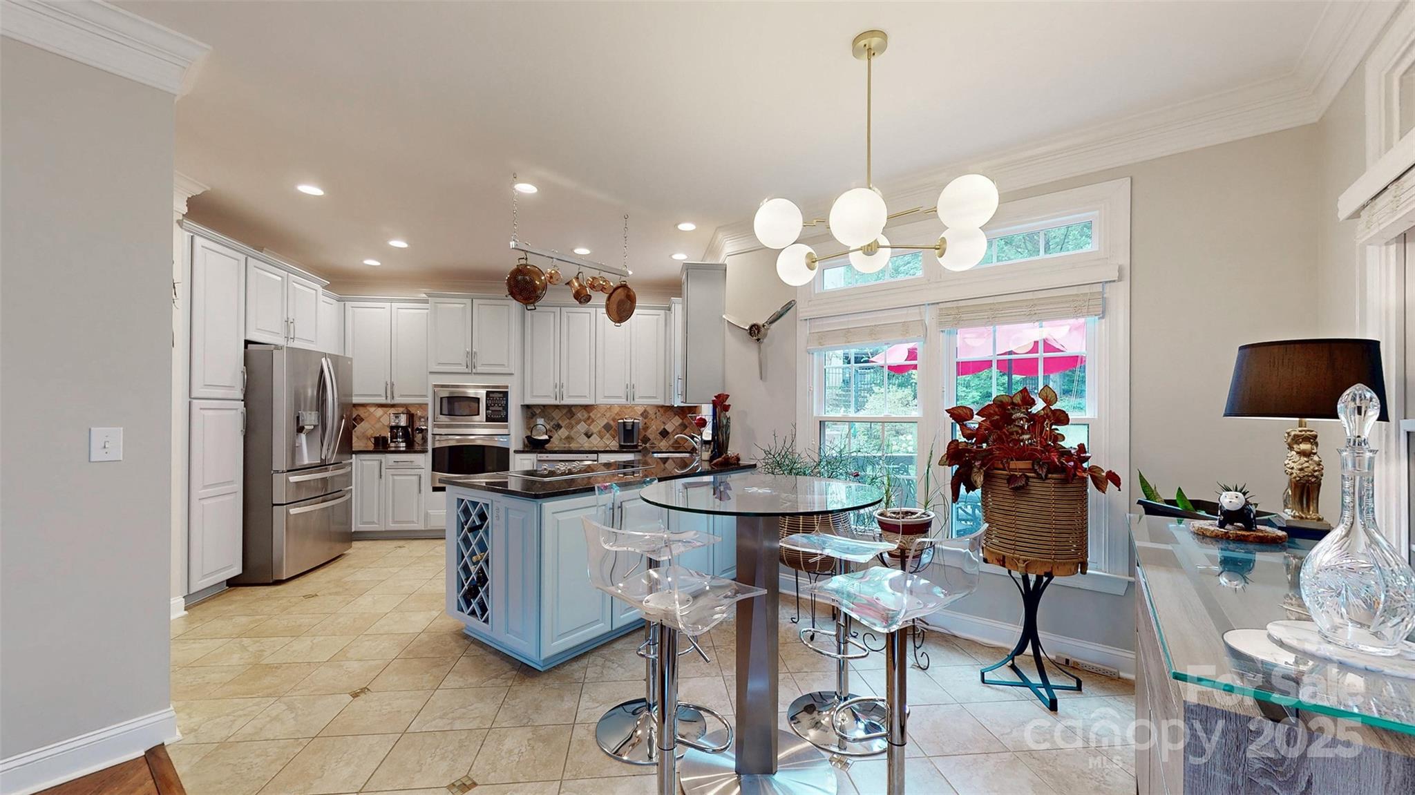 9014 Cardinal Ridge Court Charlotte, NC 28270 - Photo 31 of 45 a kitchen room with stainless steel appliances kitchen island granite countertop a table chairs and a refrigerator