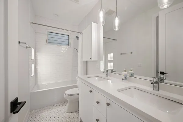 a bathroom with a granite countertop sink a toilet and a large mirror
