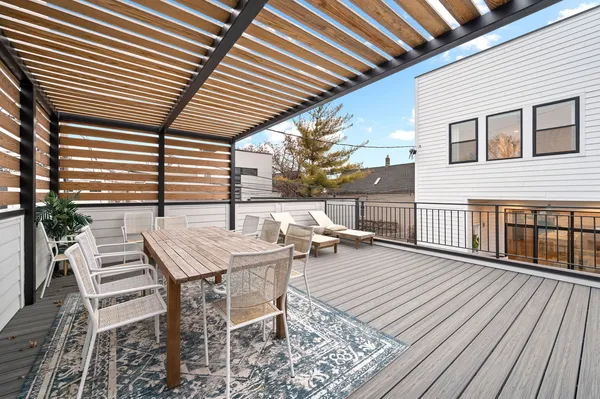 a view of a patio with table and chairs with wooden floor and fence and a floor to ceiling window