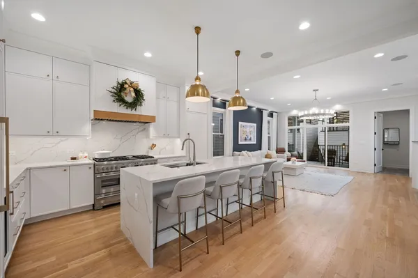 a kitchen with stainless steel appliances granite countertop a stove and a wooden floors
