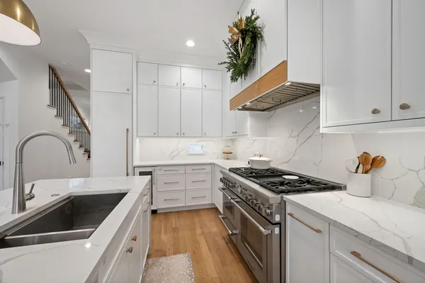 a kitchen with stainless steel appliances granite countertop a sink stove and cabinets