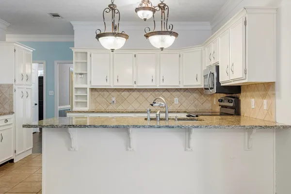 a kitchen with stainless steel appliances granite countertop a sink a stove and cabinets