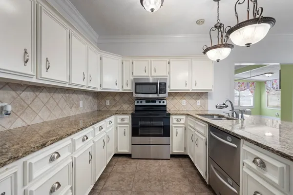 a kitchen with granite countertop a stove sink and cabinets