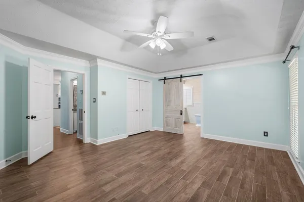 a view of an empty room with wooden floor