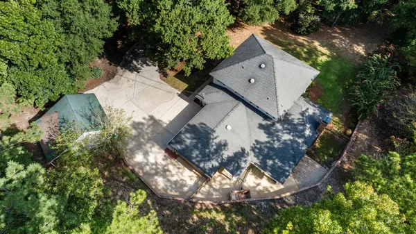 an aerial view of a house with a yard and large tree