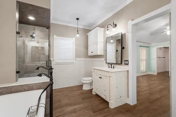 a bathroom with a bathtub shower sink mirror and toilet