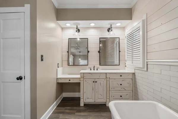 a bathroom with a tub sink and mirror