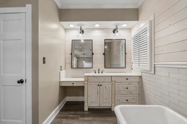 a bathroom with a tub sink and mirror