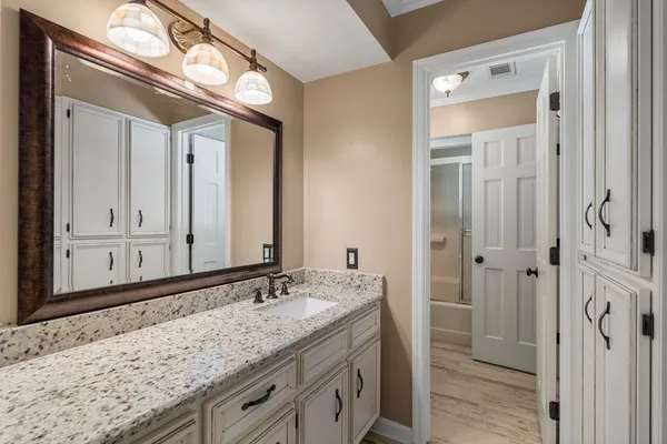 a bathroom with a granite countertop sink and a mirror