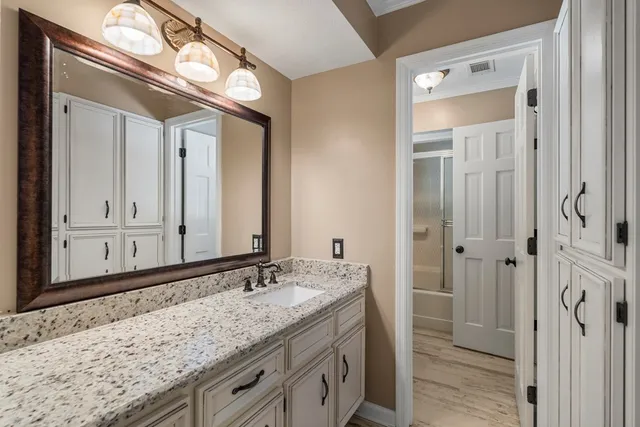 a bathroom with a granite countertop sink and a mirror