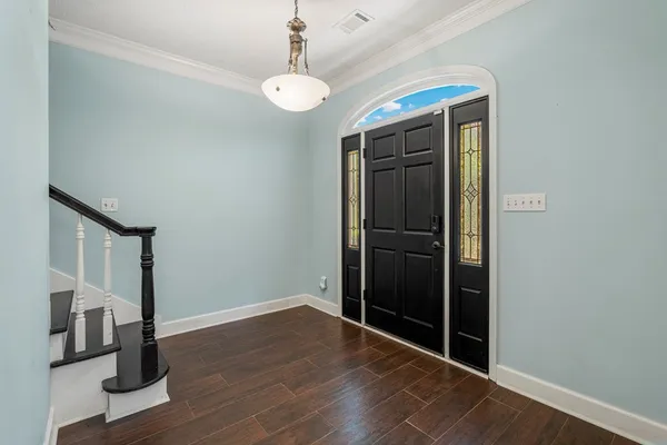 a view of empty room with wooden floor