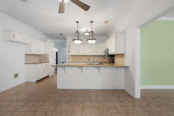 a large kitchen with cabinets and wooden floor