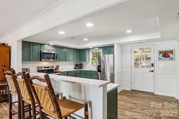 a kitchen with stainless steel appliances granite countertop a refrigerator and a stove top oven