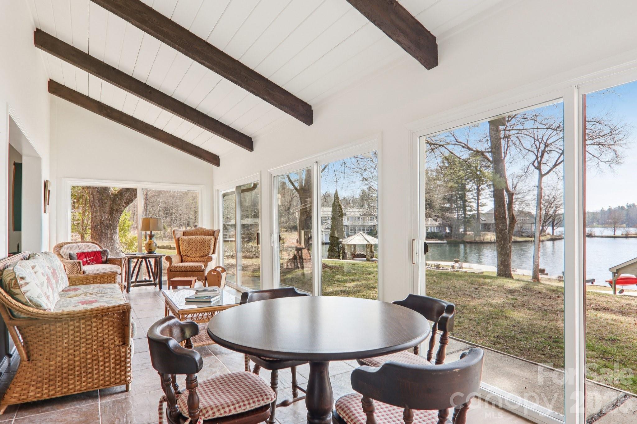 987 Cold Mountain Road Lake Toxaway, NC 28747 - Photo 22 of 42 a view of a dining room with furniture large windows and wooden floor