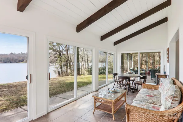 a dining room with furniture and large windows