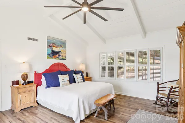 a bedroom with a bed and wooden floor