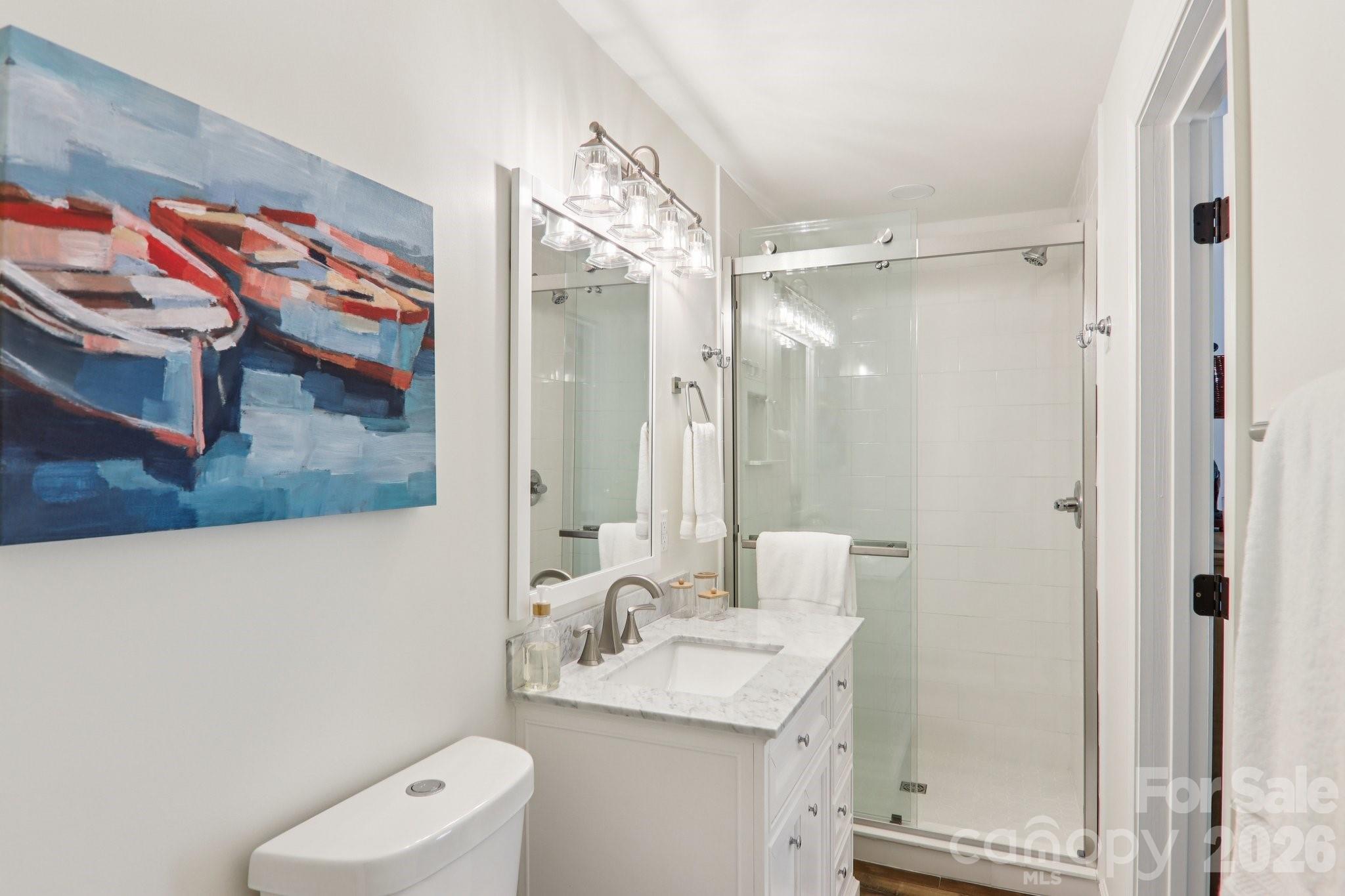 987 Cold Mountain Road Lake Toxaway, NC 28747 - Photo 27 of 42 a bathroom with a granite countertop sink a mirror and a shower