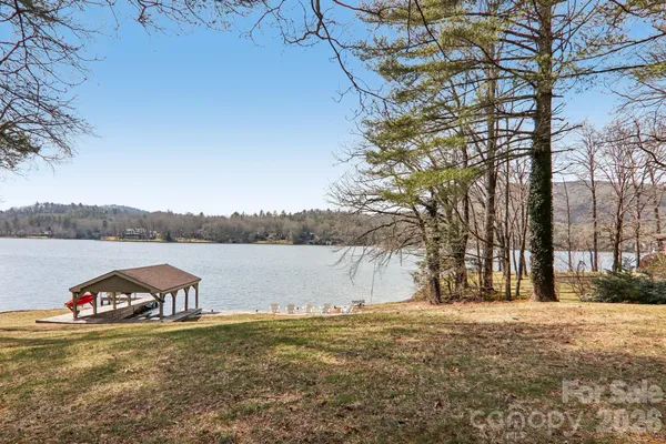 a view of a lake with a yard and large trees