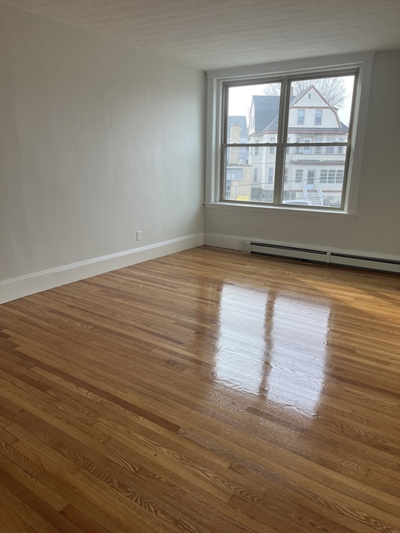 108 Bristol Road, Unit 1 Somerville, MA 02144 - Photo 10 of 30 wooden floor in an empty room with a window