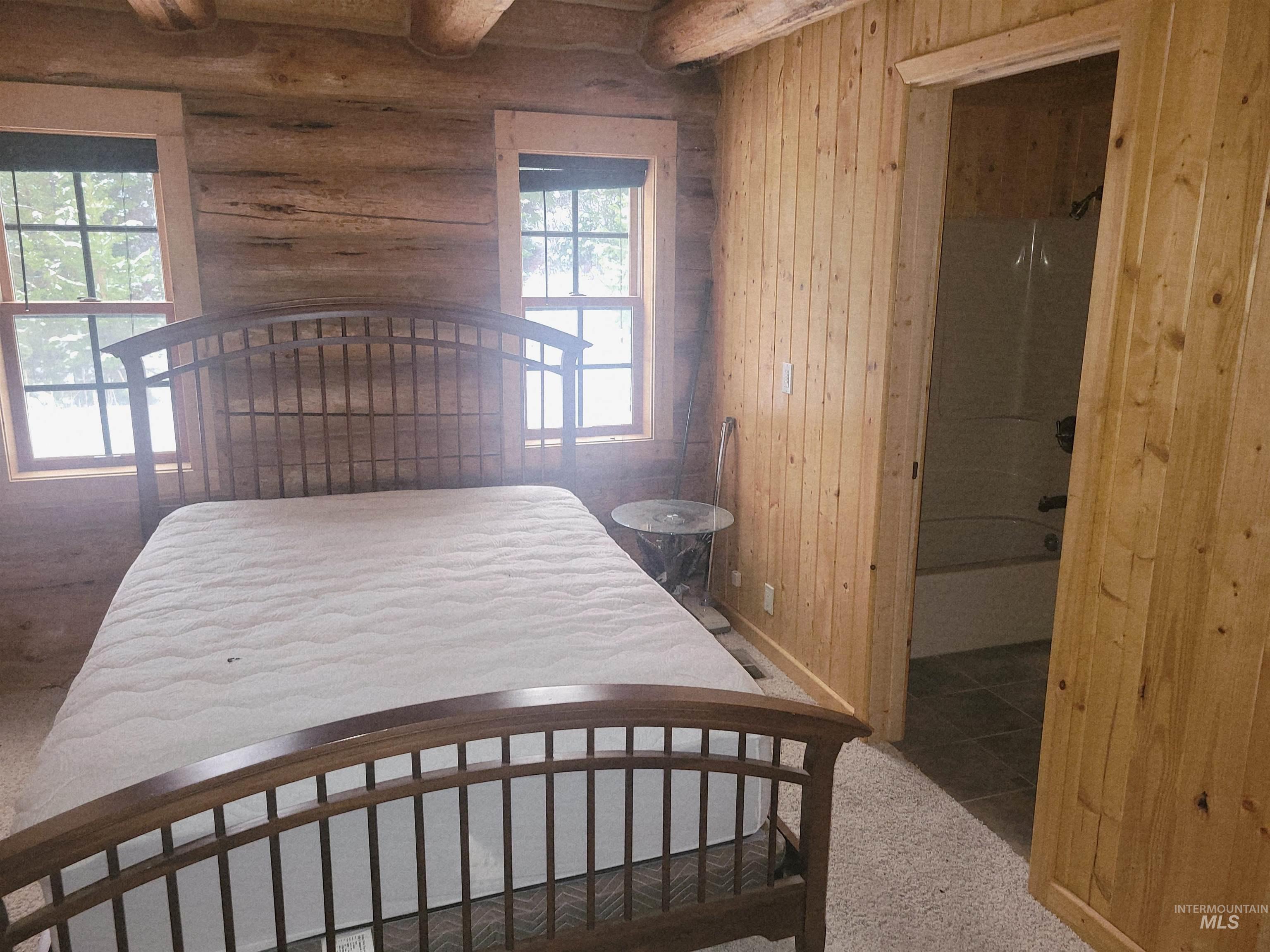 129 Copperhead Road Elk City, ID 83525 - Photo 21 of 28 Bedroom with wooden walls, carpet flooring, and beamed ceiling
