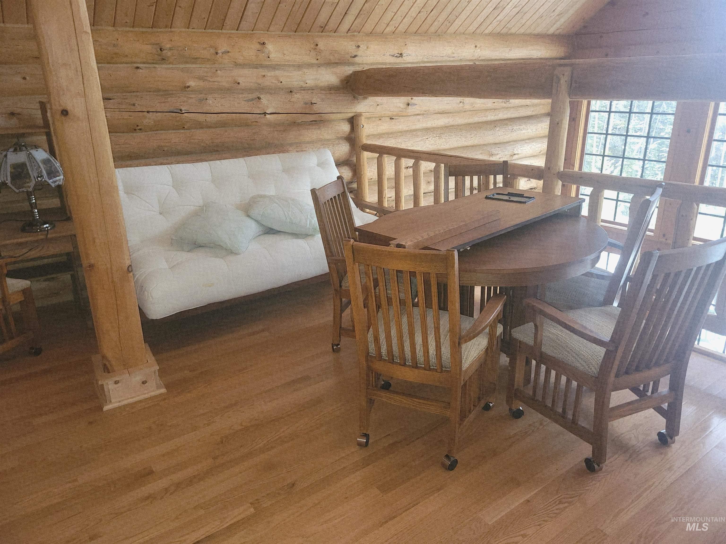 129 Copperhead Road Elk City, ID 83525 - Photo 22 of 28 Dining area with log walls, wood finished floors, and wooden ceiling