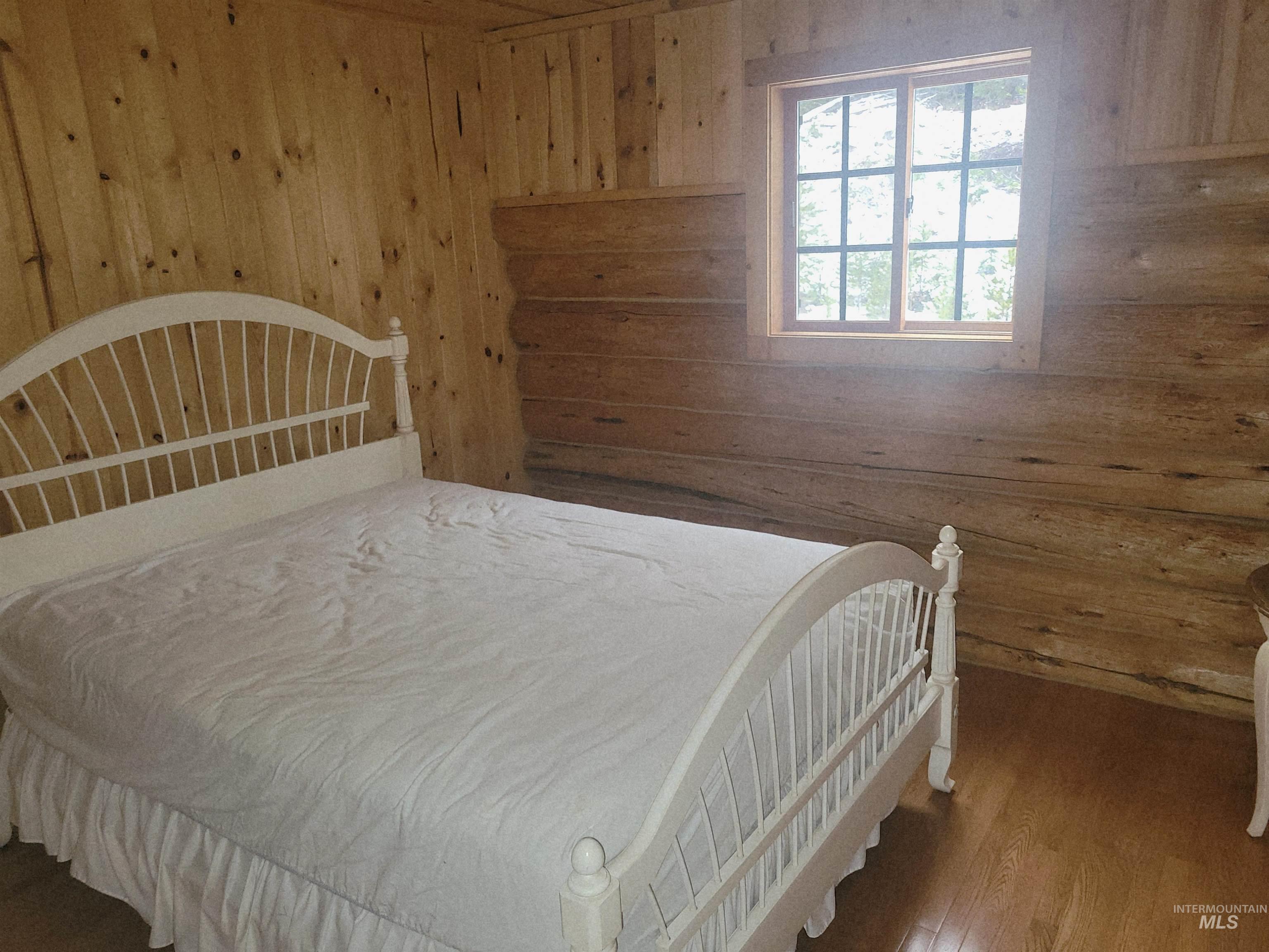 129 Copperhead Road Elk City, ID 83525 - Photo 24 of 28 Bedroom featuring wooden walls and wood finished floors
