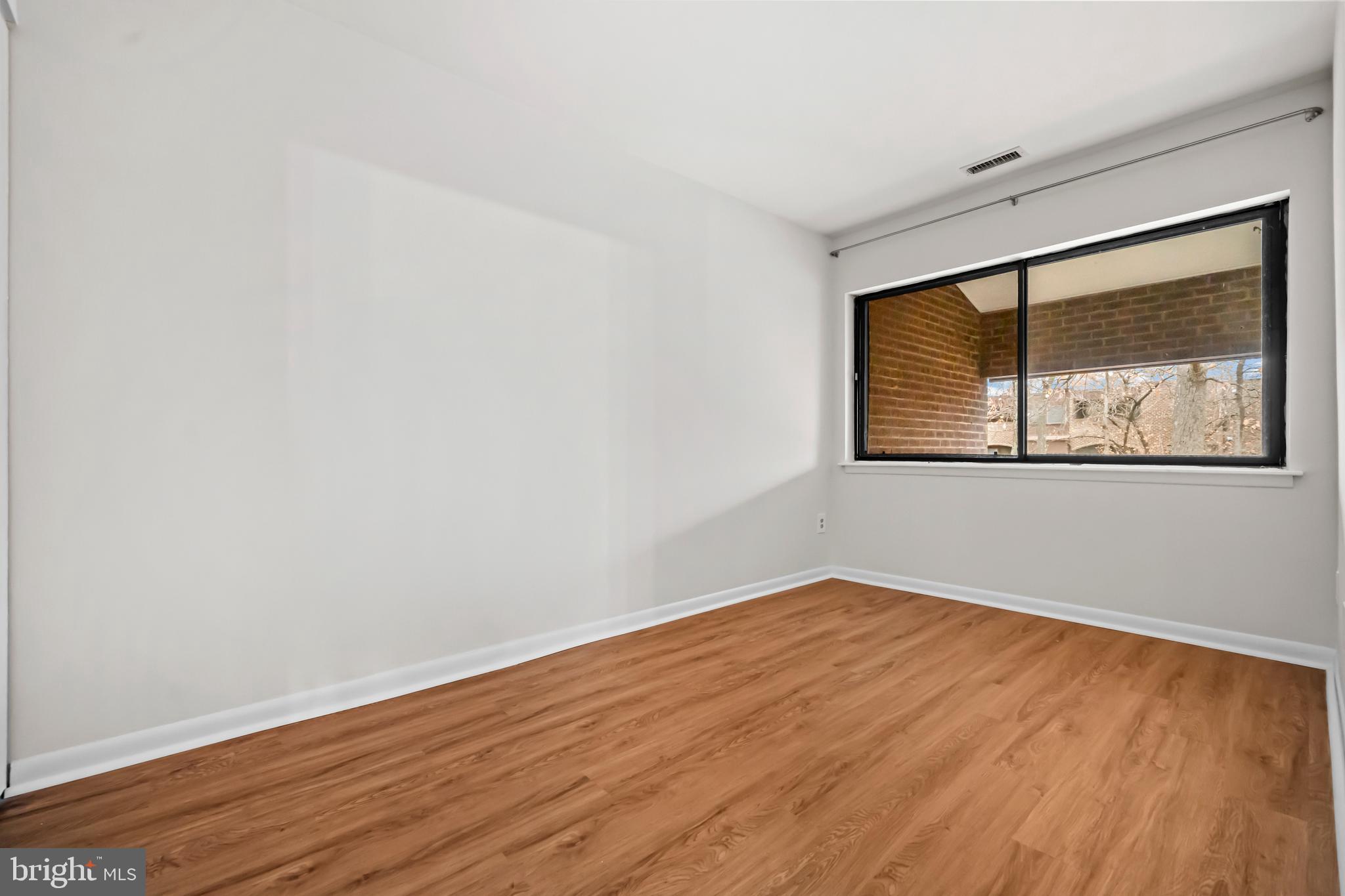 11200 Chestnut Grove Square, Unit 203 Reston, VA 20190 - Photo 21 of 41 a view of empty room with wooden floor and fan