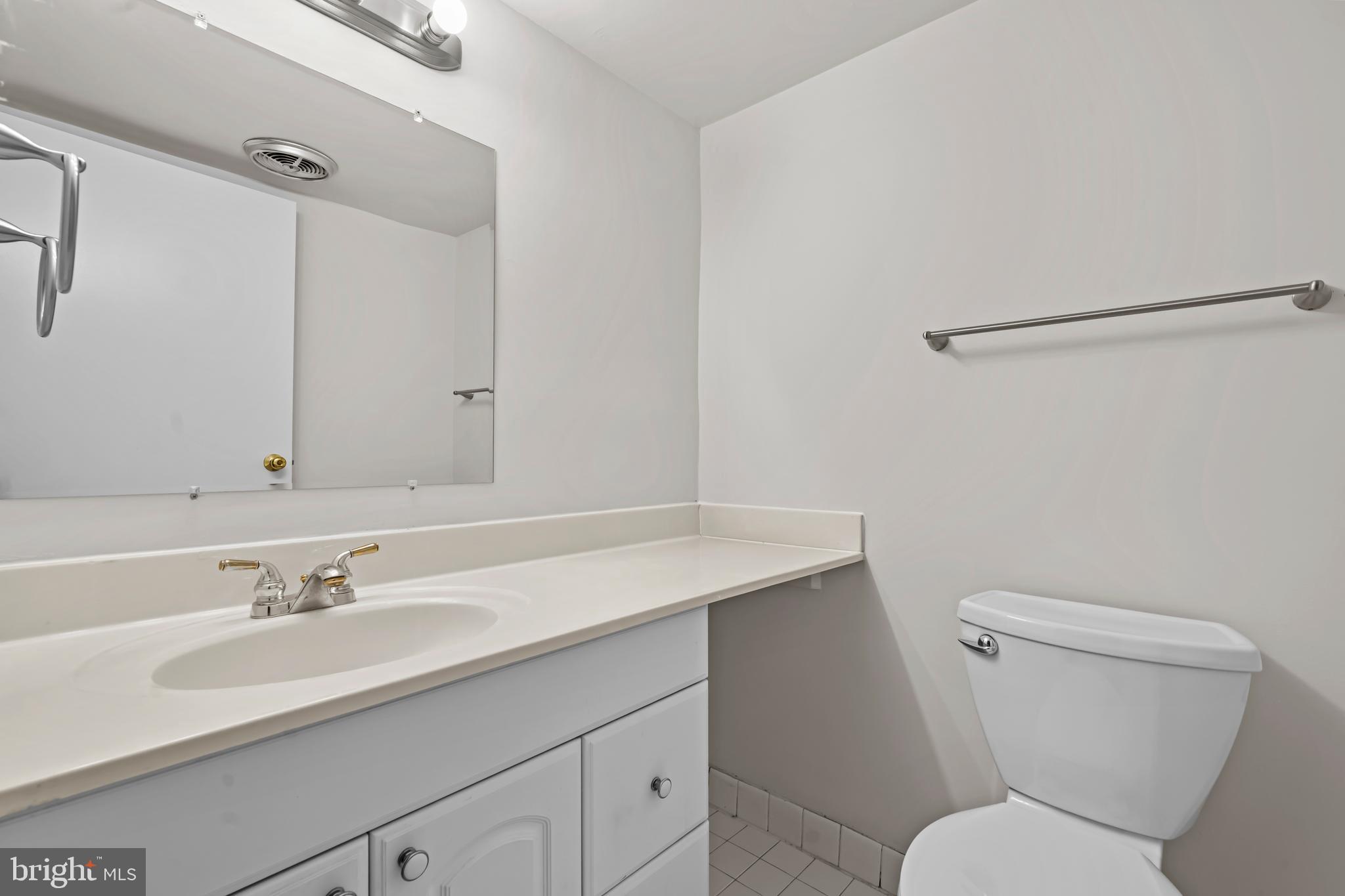 11200 Chestnut Grove Square, Unit 203 Reston, VA 20190 - Photo 24 of 41 a bathroom with a toilet sink and a mirror