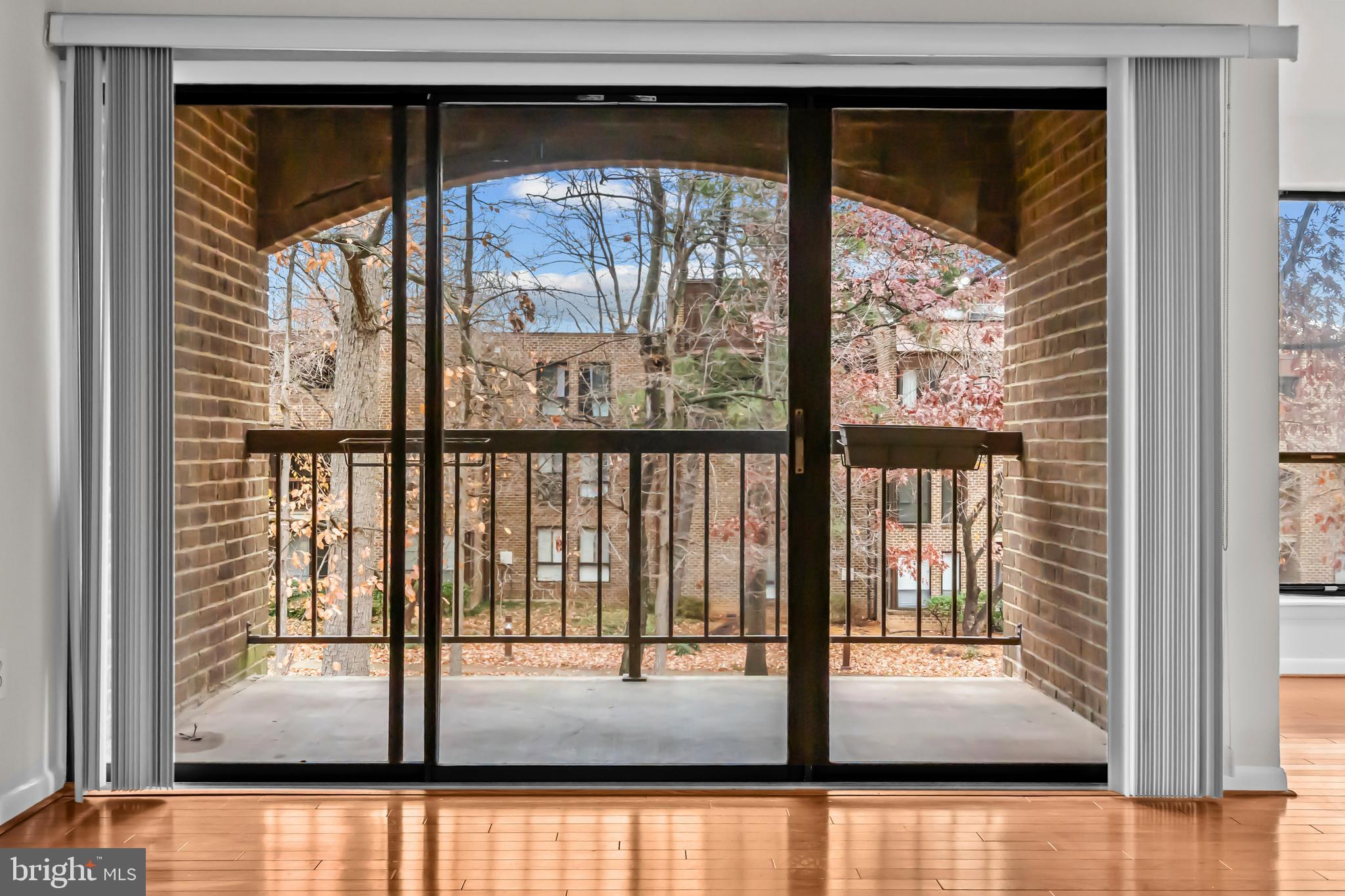 11200 Chestnut Grove Square, Unit 203 Reston, VA 20190 - Photo 6 of 41 a view of empty room with wooden floor and floor to ceiling window