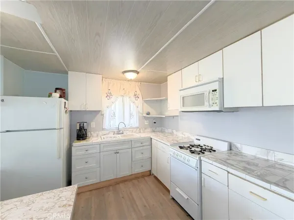 a kitchen with white cabinets sink and white appliances