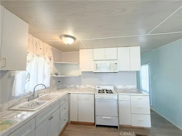 a kitchen with sink a stove and cabinets