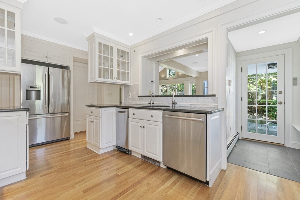 9 Larch Road Newton, MA 02468 - Photo 11 of 34 a kitchen with granite countertop white cabinets and white appliances