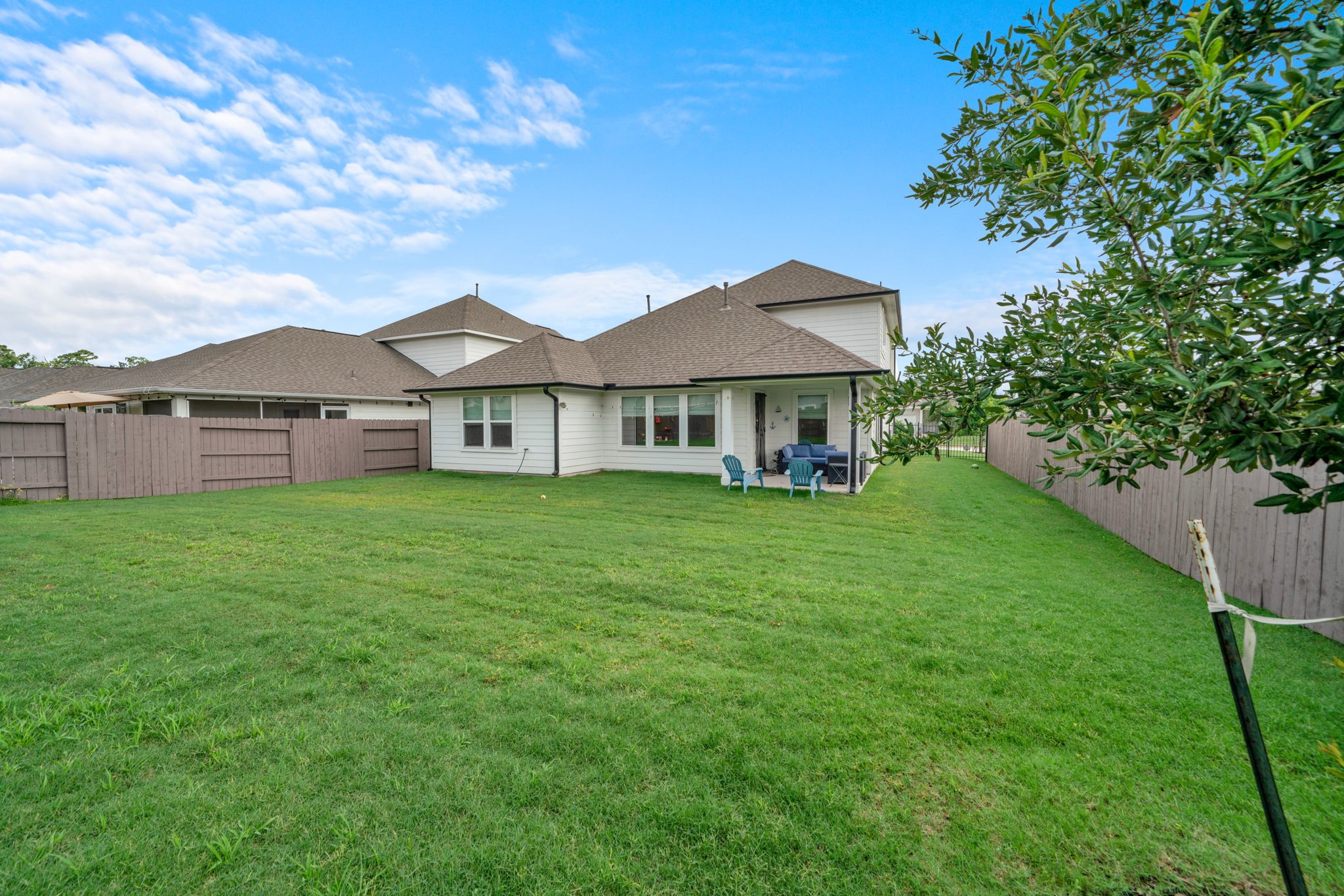 2503 Hagerman Road Conroe, TX 77384 - Photo 4 of 43 Spacious backyard with a well-maintained lawn, privacy fence, and a cozy patio area, perfect for outdoor activities and relaxation.