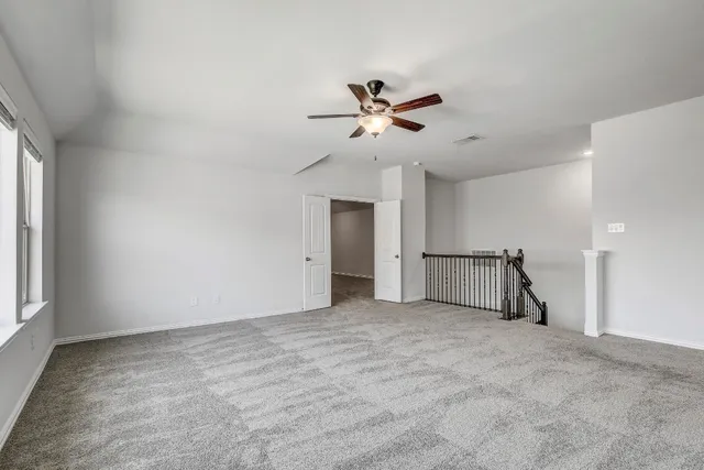 a view of empty room with ceiling fan