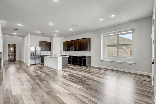 a view of kitchen with microwave a stove and wooden floor