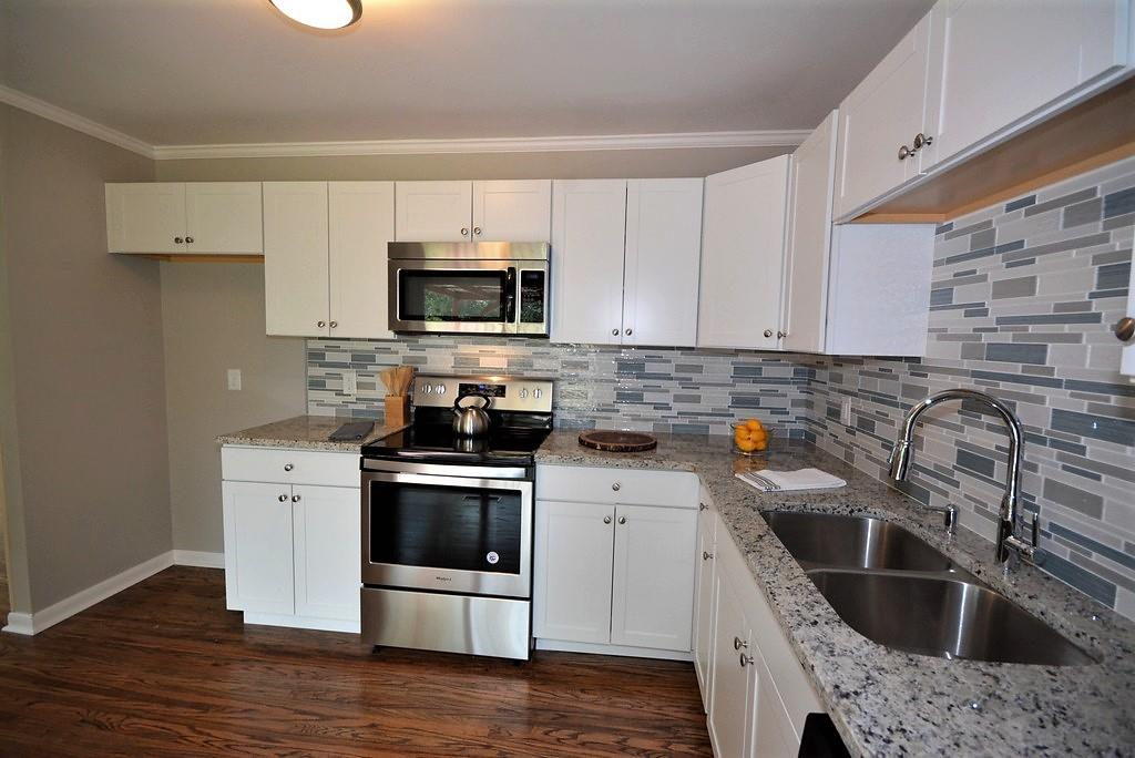 3017 Anderson Road Nashville, TN 37217 - Photo 8 of 29 a kitchen with stainless steel appliances a stove a sink a microwave and wooden cabinets